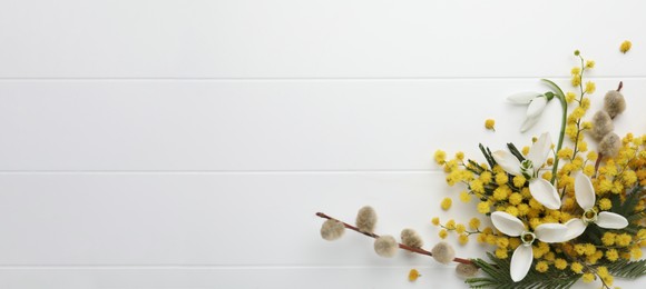 Beautiful floral composition with mimosa flowers on white wooden background, flat lay. Space for text