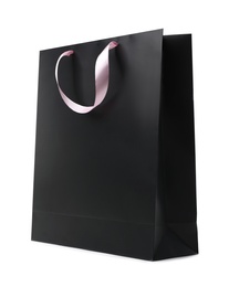 Paper shopping bag with ribbon handles on white background. Mockup for design