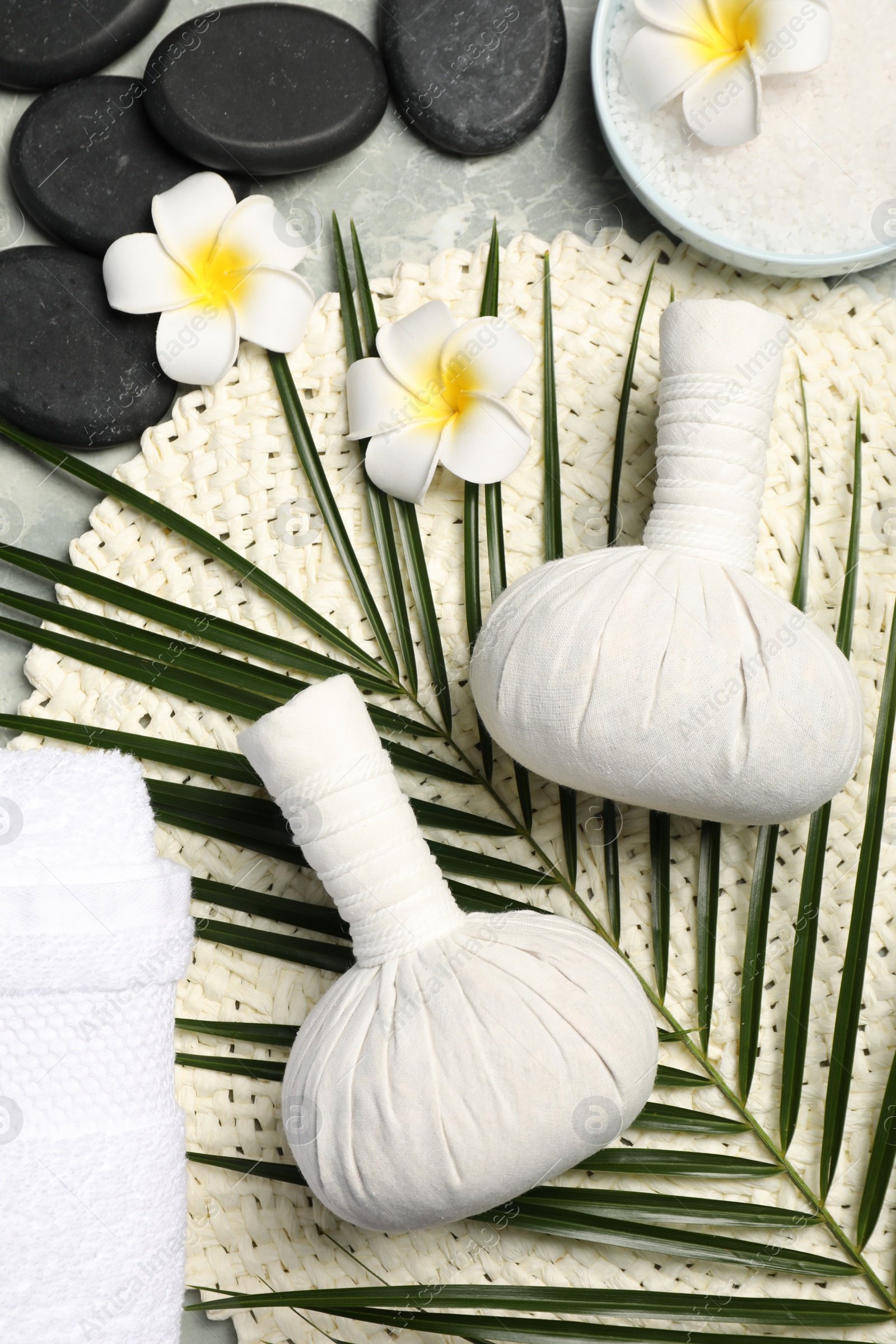 Photo of Spa bags, stones and orchid flowers on light gray marble table, flat lay