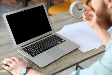 Man using video chat on laptop in home office, closeup. Space for text