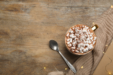 Photo of Cup of delicious hot cocoa with marshmallows on wooden table, flat lay. Space for text