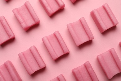 Photo of Tasty chewing gums on pink background, flat lay