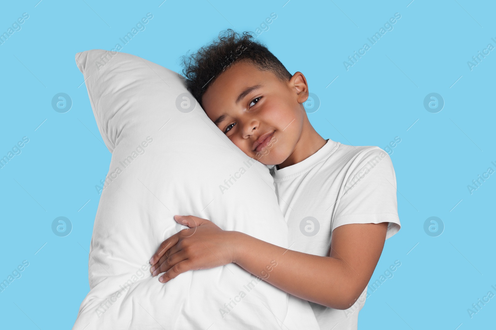 Photo of Boy with pillow on light blue background. Insomnia problem
