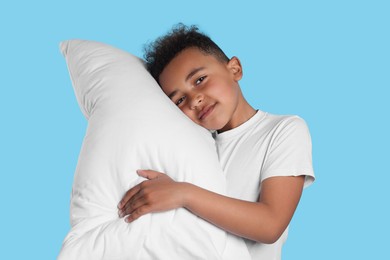 Boy with pillow on light blue background. Insomnia problem