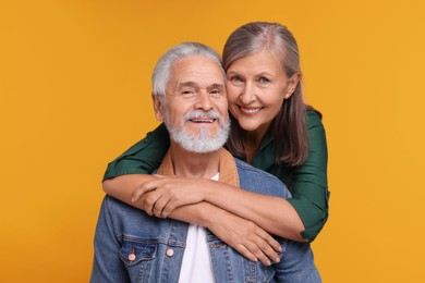 Photo of Portrait of affectionate senior couple on orange background