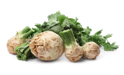 Photo of Many raw celery roots with stalks isolated on white