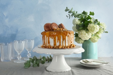 Dessert stand with delicious caramel cake on table