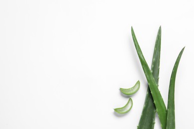 Photo of Cut aloe vera leaves on white background, flat lay. Space for text