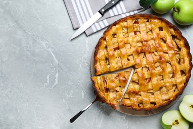 Fresh traditional apple pie and fruits on light grey table, flat lay. Space for text