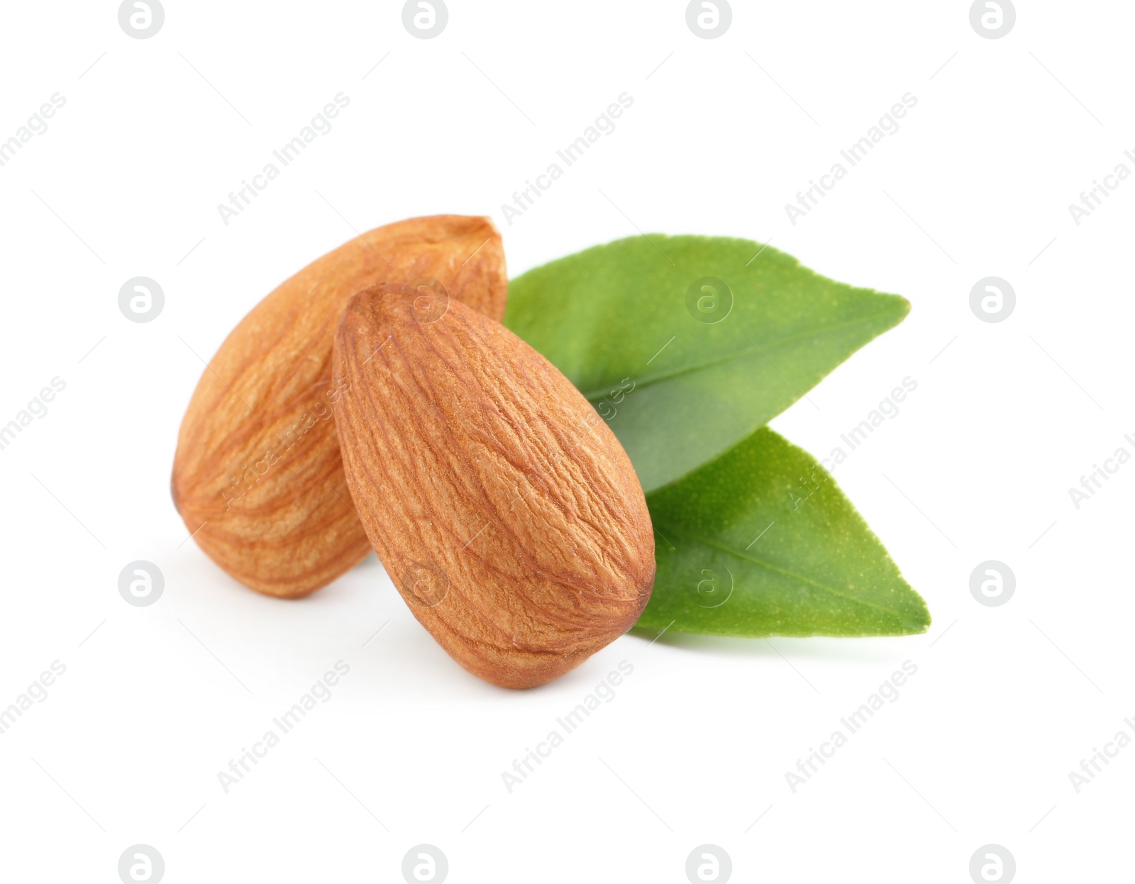 Photo of Organic almond nuts and green leaves on white background. Healthy snack
