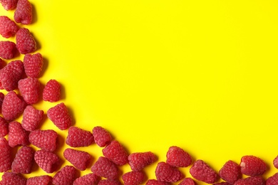 Photo of Frame made with delicious ripe raspberries on yellow background. Space for text