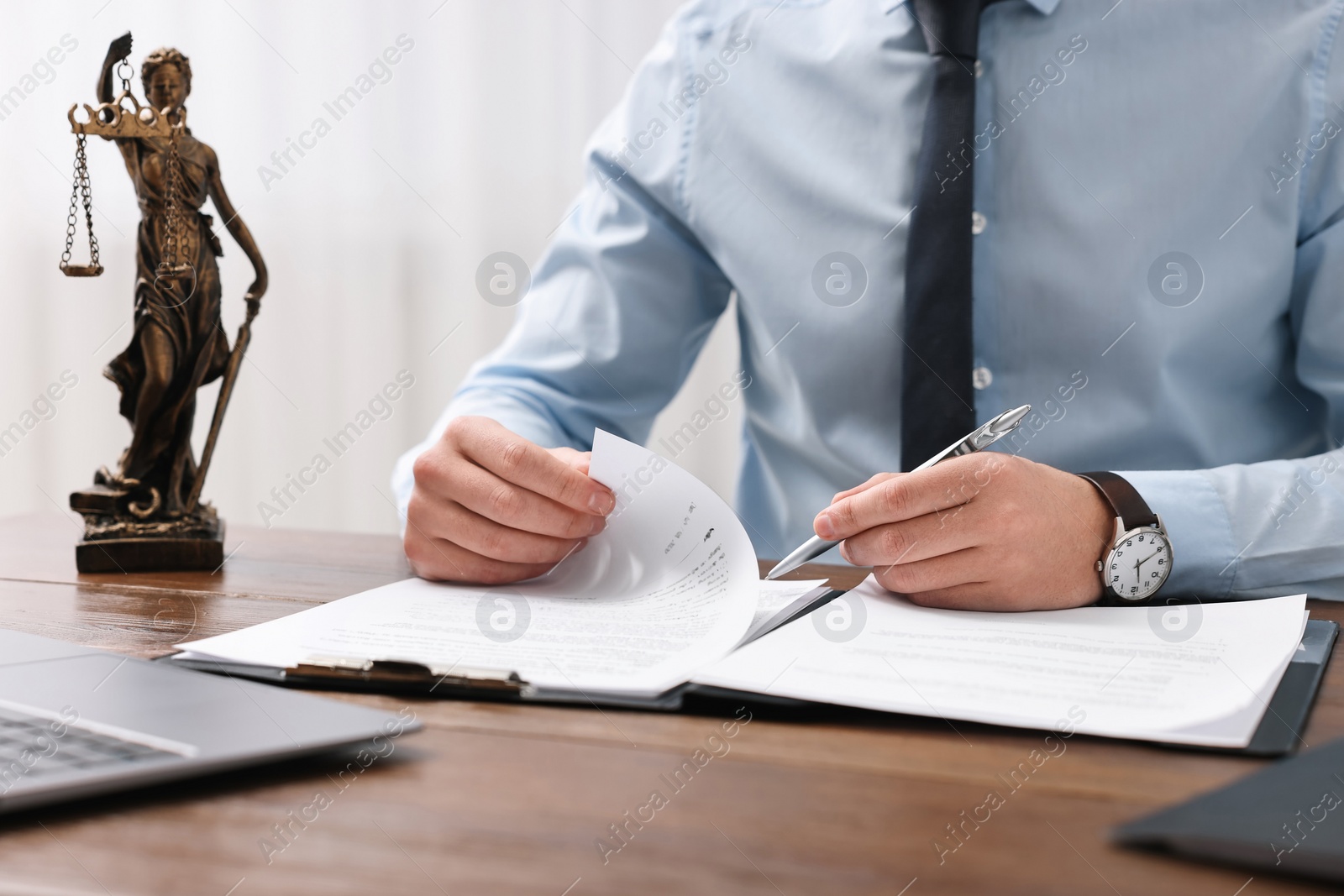 Photo of Lawyer working with documents at wooden table in office, closeup