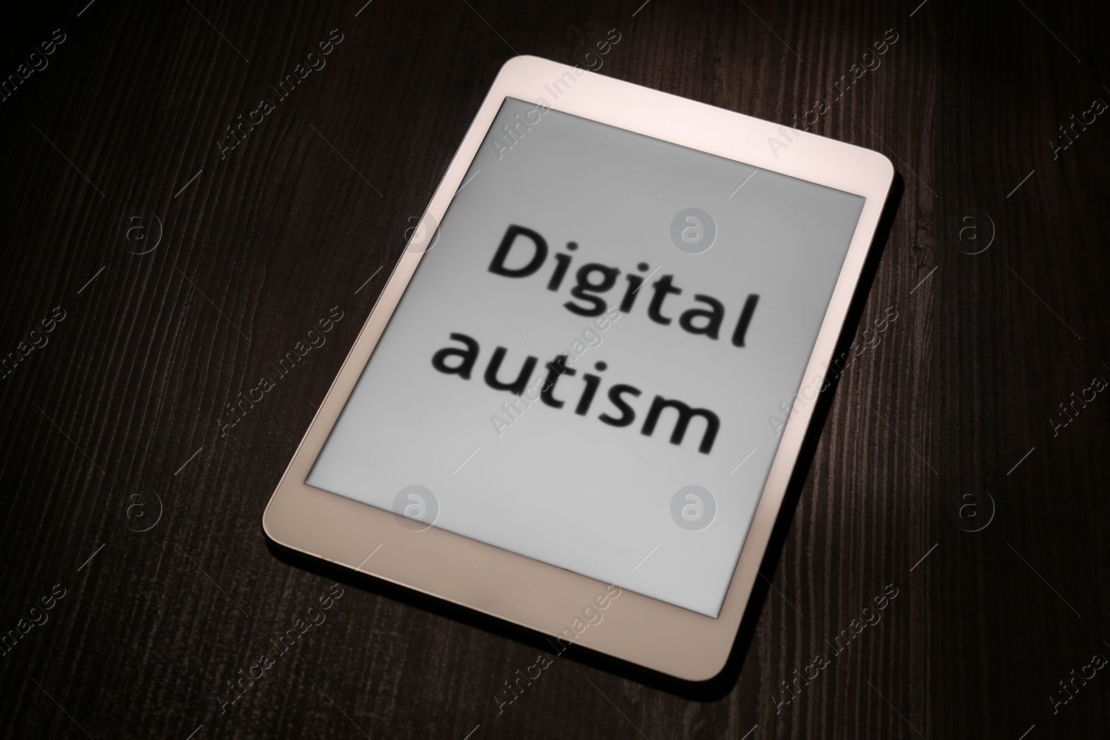Photo of Tablet with phrase Digital Autism on wooden table. Addictive behavior