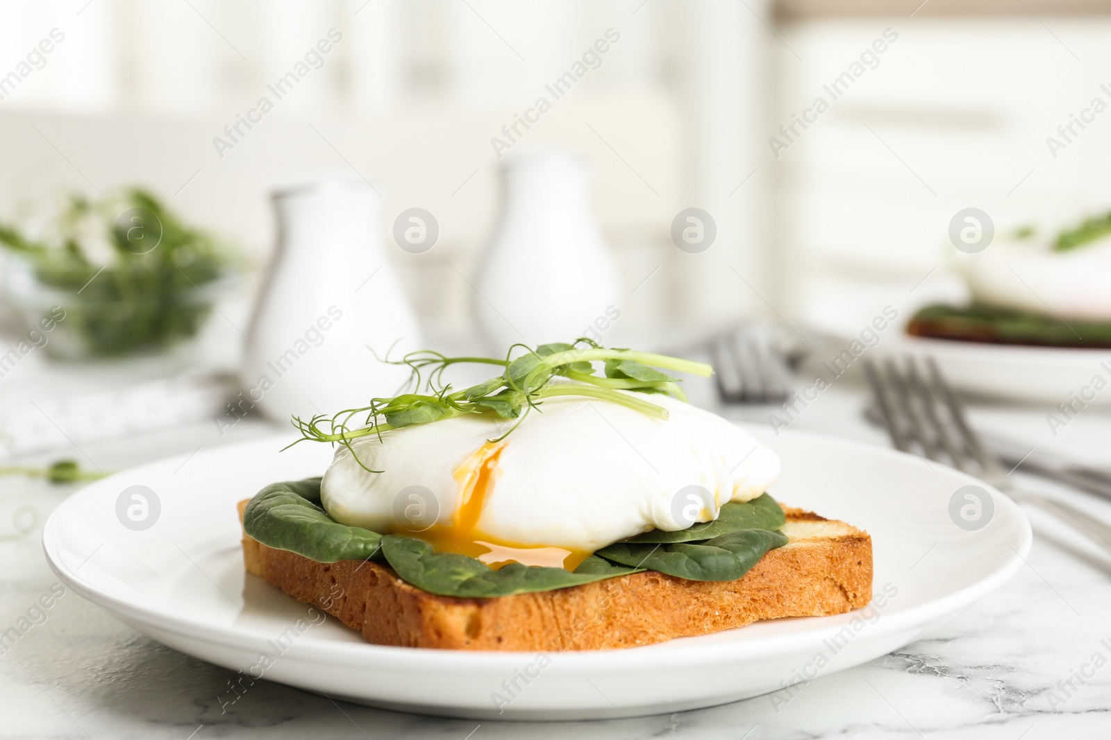 Photo of Delicious poached egg sandwich served on white marble table