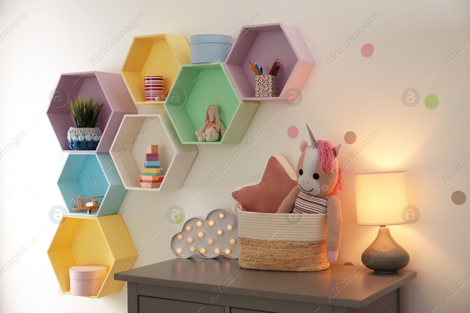 Photo of Bright colorful shelves on light wall in room. Interior design