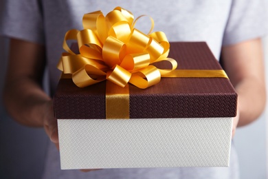 Photo of Woman holding beautiful gift box with bow, closeup