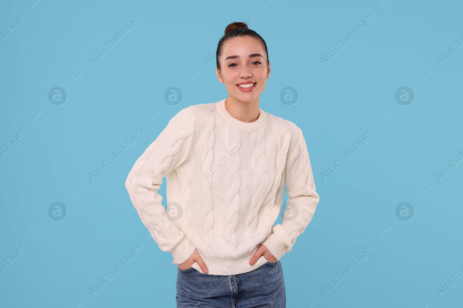 Photo of Beautiful young woman in stylish warm sweater on light blue background