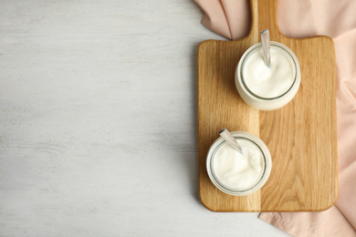 Tasty organic yogurt on white wooden table, flat lay. Space for text