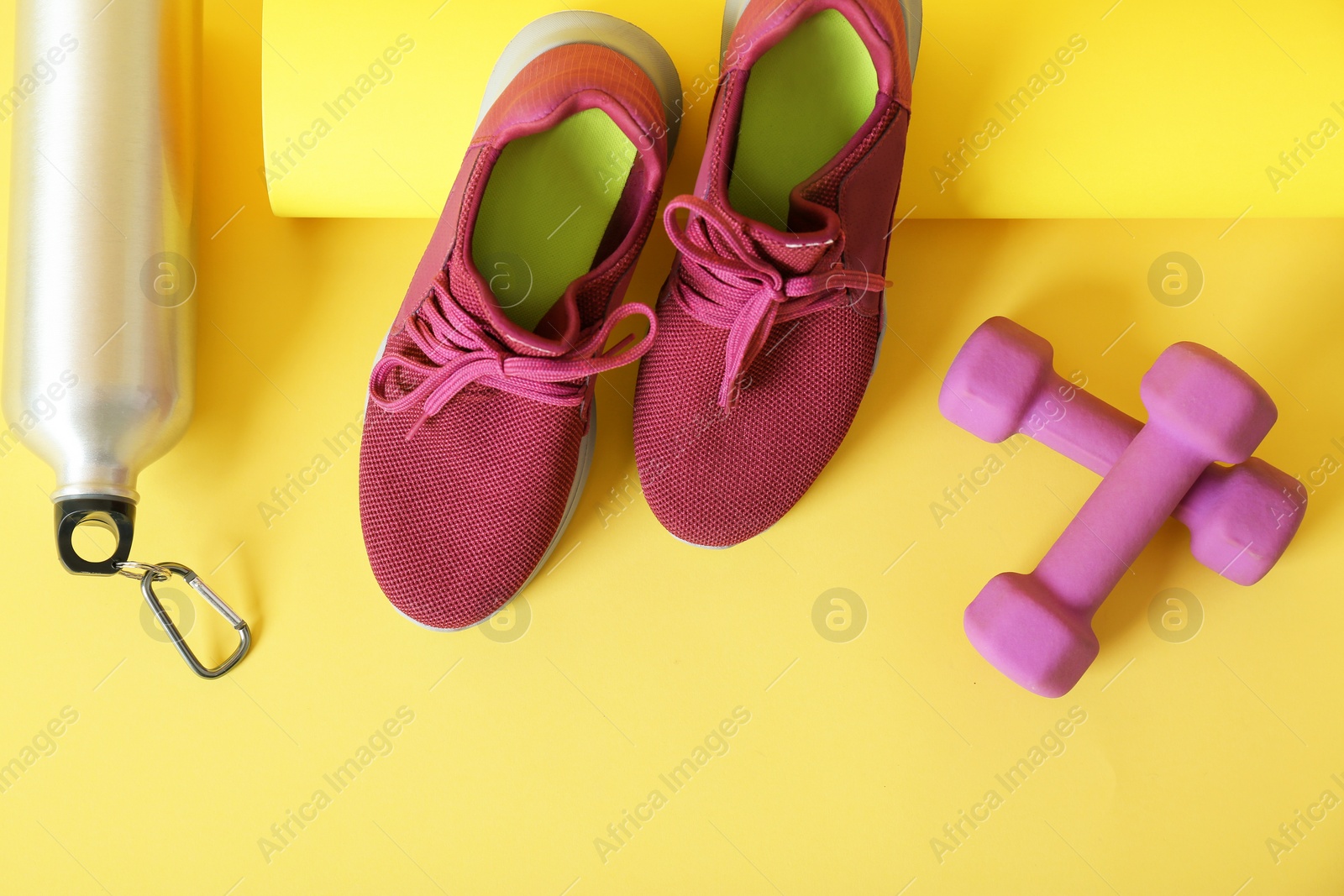 Photo of Flat lay composition with fitness equipment on color background