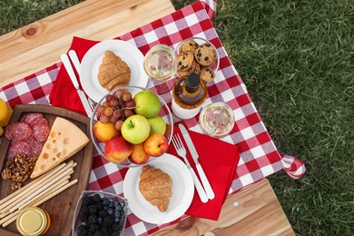 Picnic table with different tasty snacks, top view