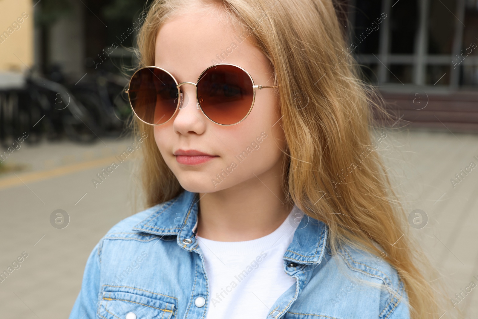 Photo of Girl wearing stylish sunglasses on street near building