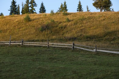 Beautiful view with wooden fence and different trees outdoors