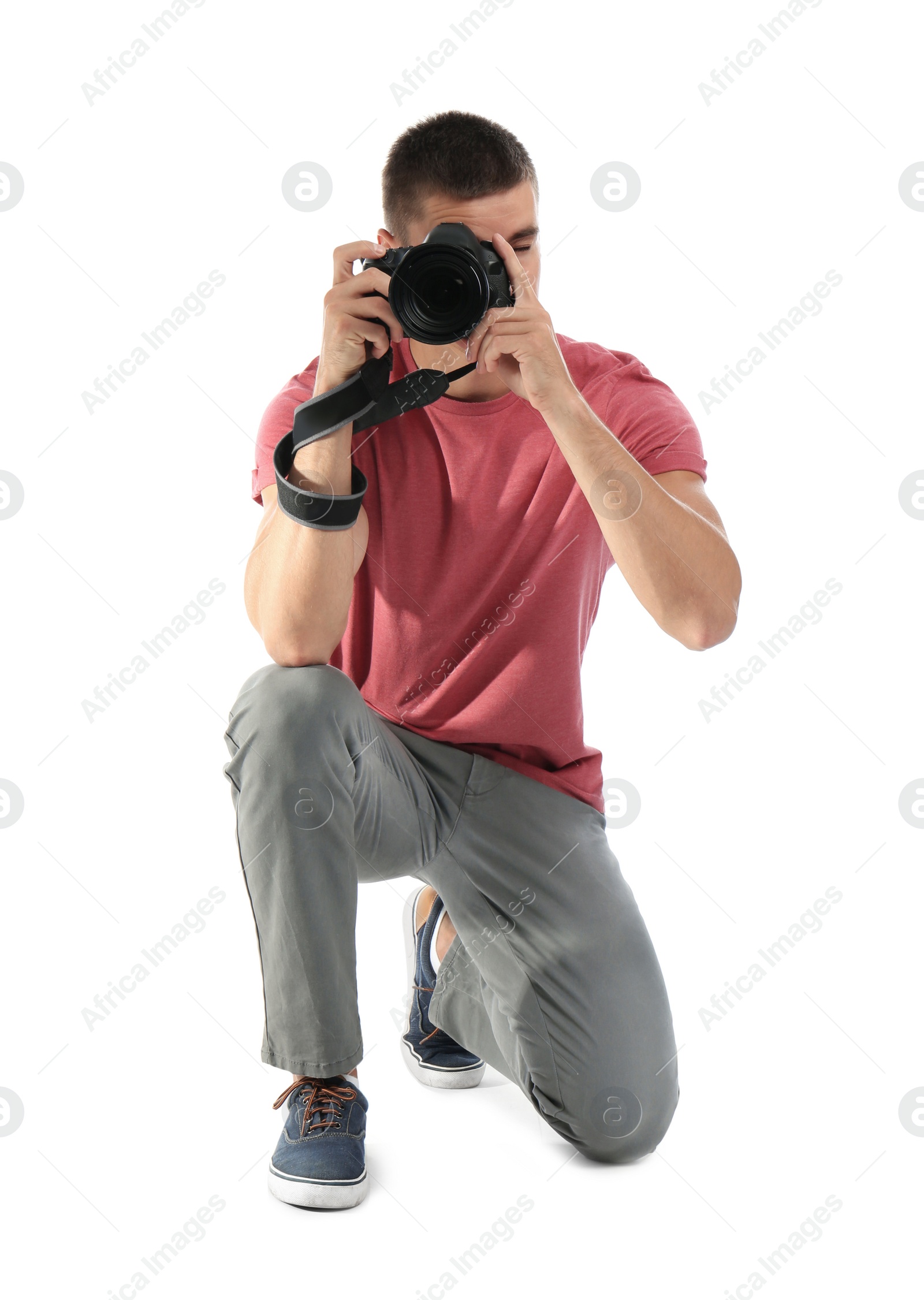 Photo of Young professional photographer taking picture on white background