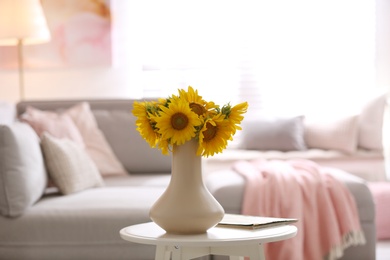 Photo of Beautiful bouquet of sunflowers in vase on white table indoors