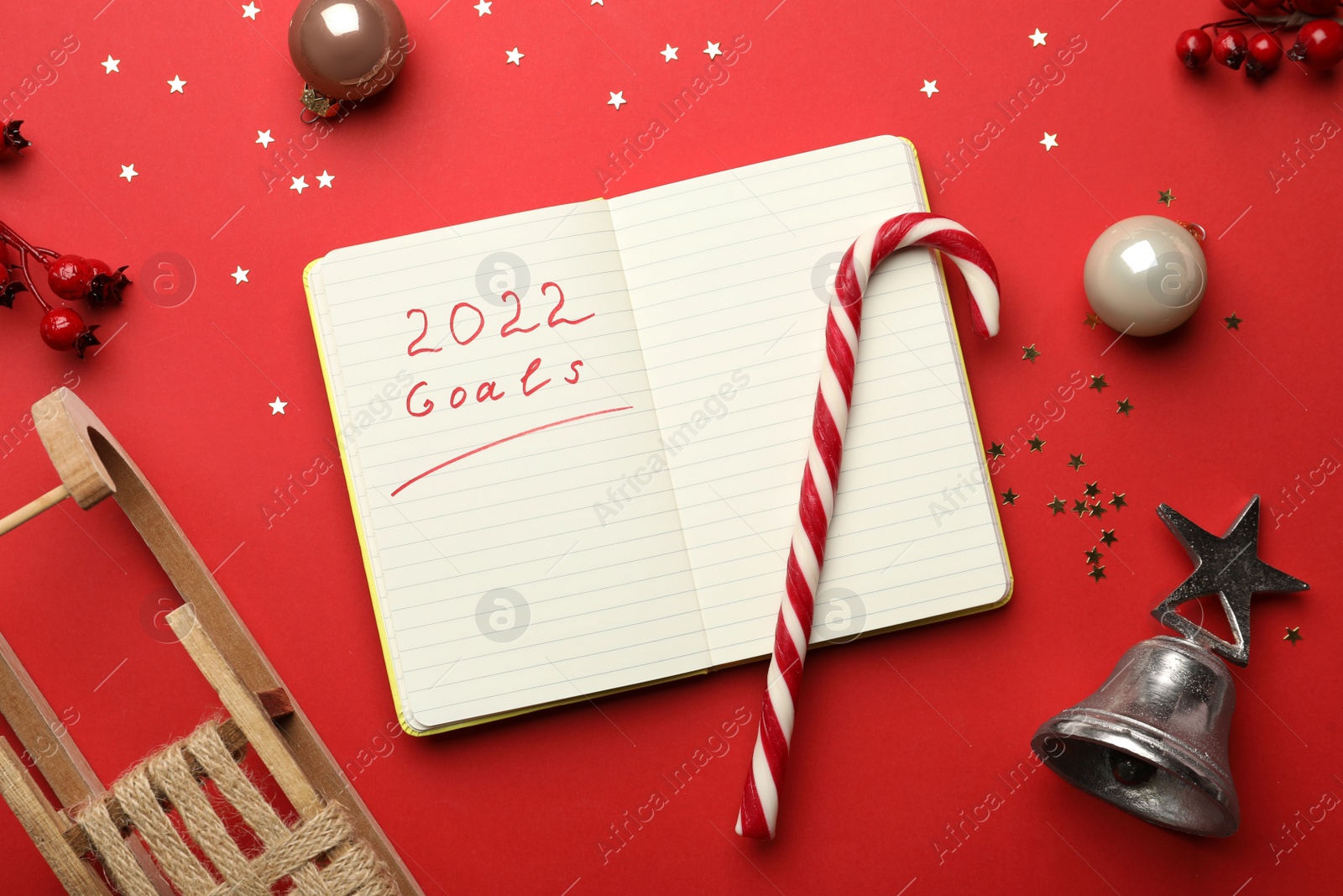 Photo of Open planner and Christmas decor on red background, flat lay. Planning for 2022 New Year