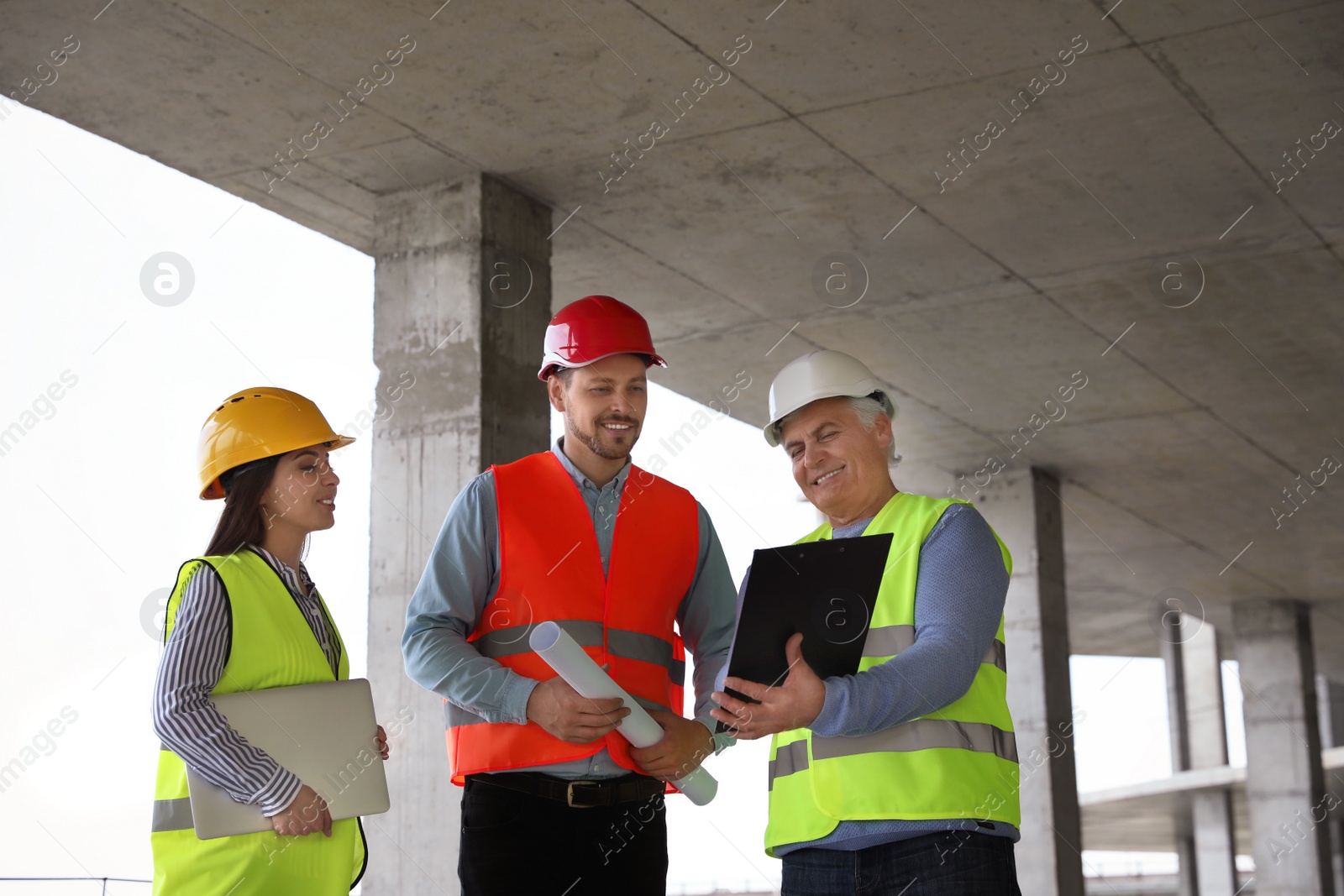 Photo of Professional engineers in safety equipment at construction site