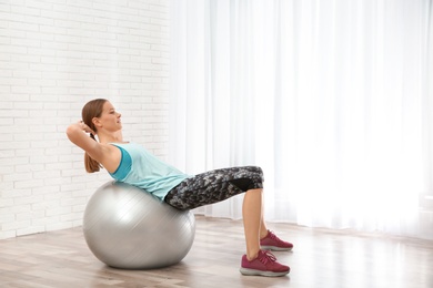 Photo of Young woman doing fitness exercises at home. Space for text