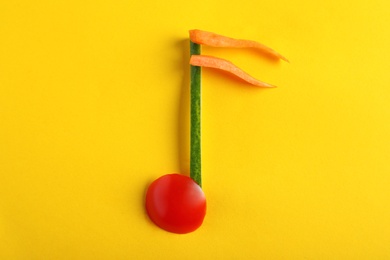 Photo of Musical note made of vegetables on color background, top view