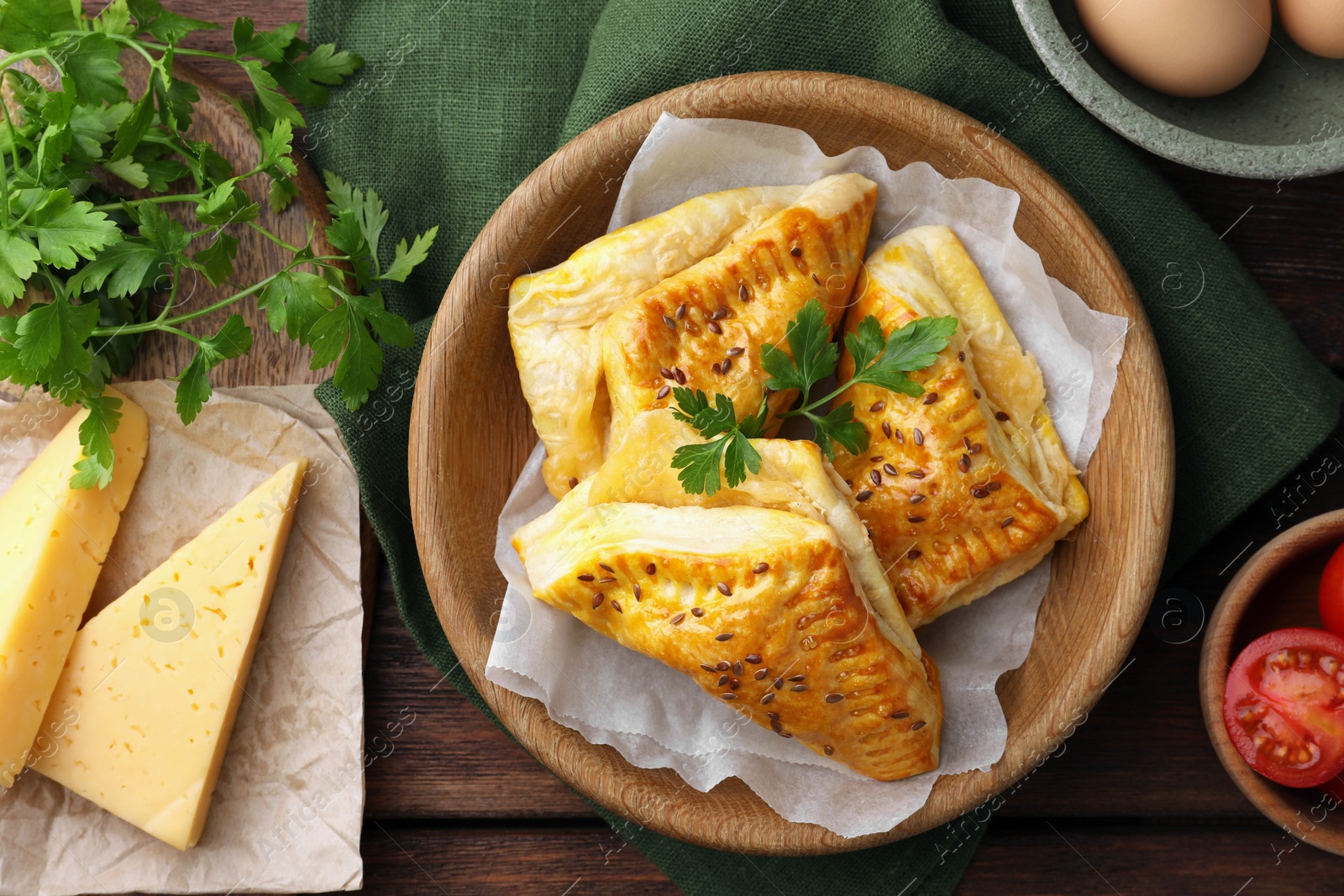 Photo of Fresh delicious puff pastry and ingredients on wooden table, flat lay