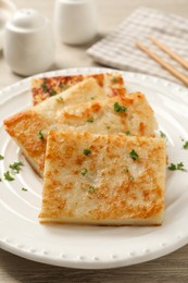Photo of Delicious turnip cake with parsley served on wooden table, closeup