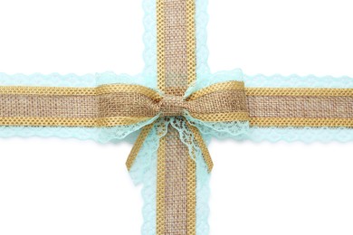 Photo of Burlap ribbons and bow with light blue lace on white background, top view