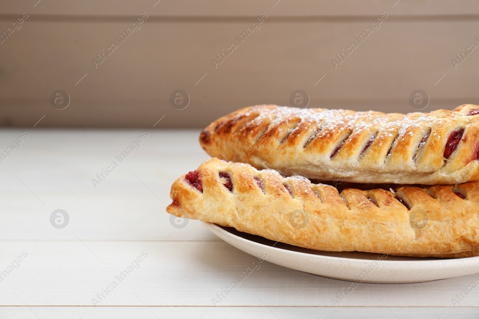 Photo of Fresh tasty puff pastry with sugar powder on white wooden table, closeup. Space for text