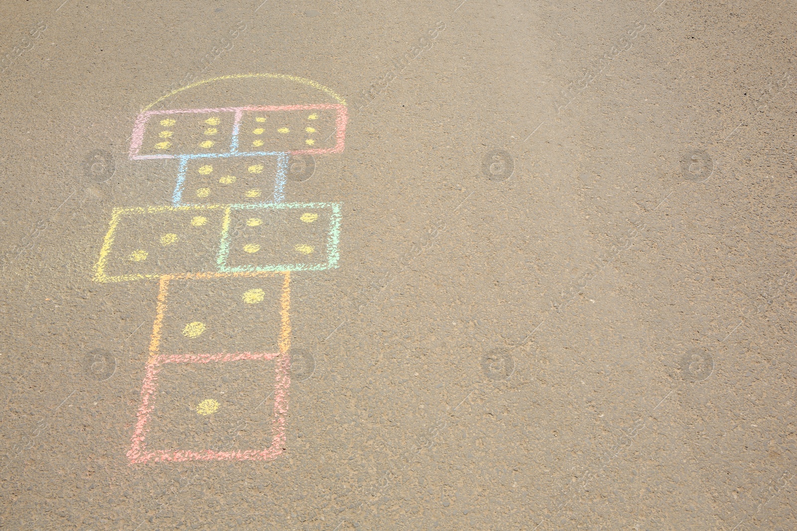 Photo of Hopscotch drawn with colorful chalk on asphalt outdoors. Space for text