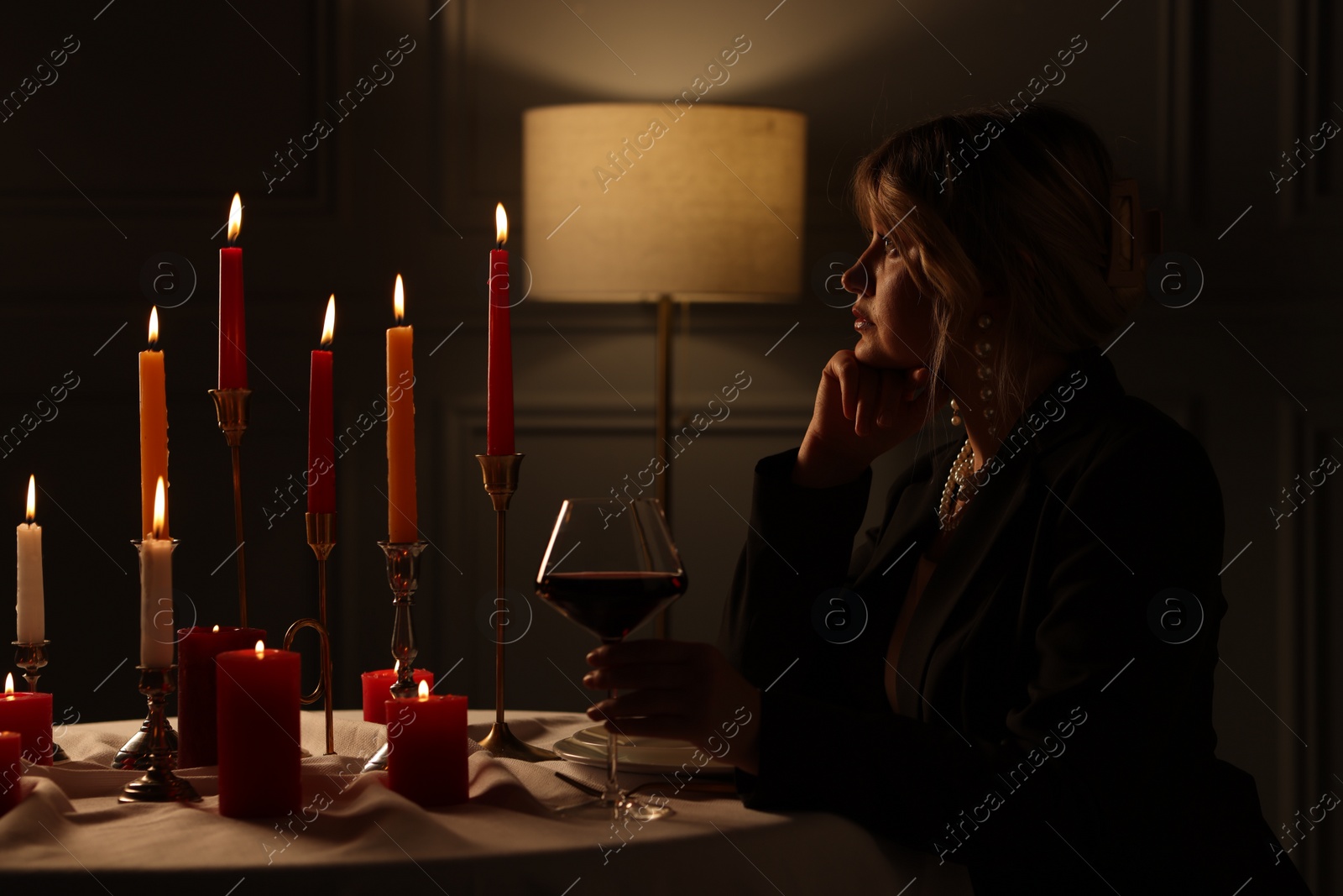 Photo of Beautiful young woman with glass of wine at table in restaurant