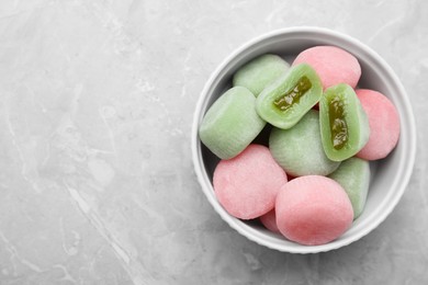 Photo of Delicious mochi in bowl on light grey marble table, top view with space for text. Traditional Japanese dessert