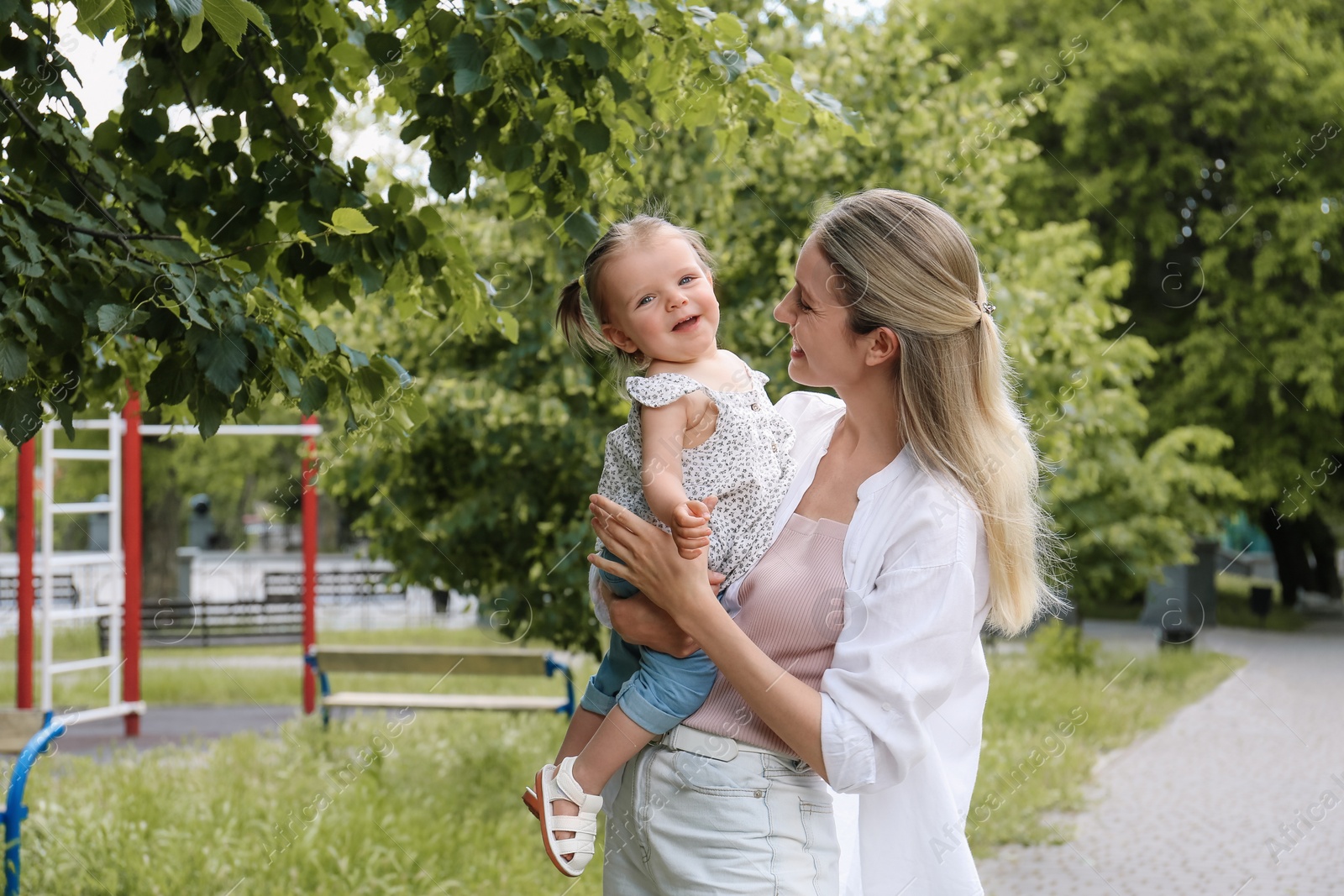 Photo of Happy mother with her daughter spending time together in park. Space for text