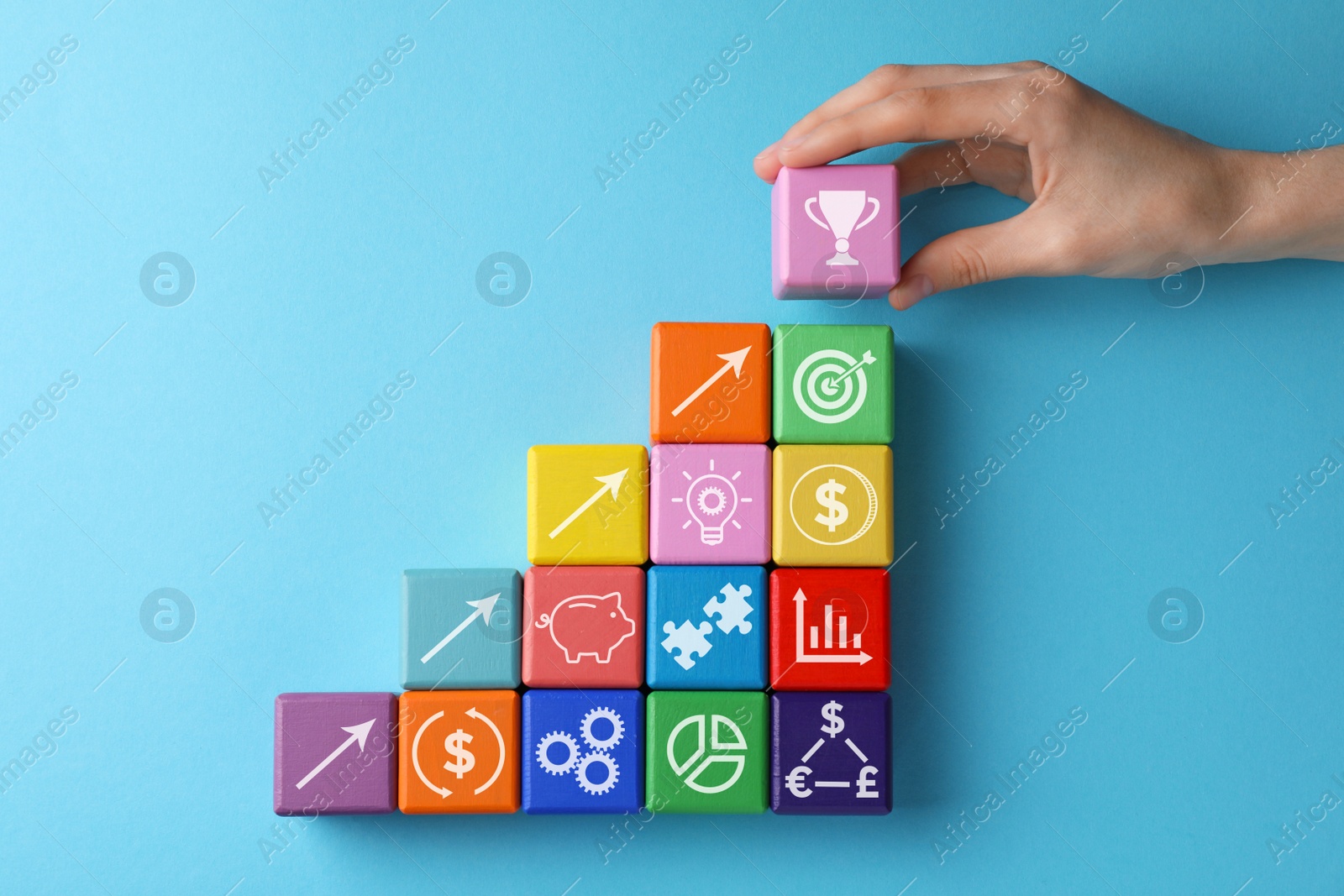 Image of Top view of woman and colorful cubes with different images on light blue background