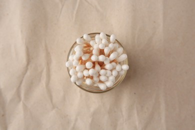 Photo of Jar of clean cotton buds on crumpled paper, top view