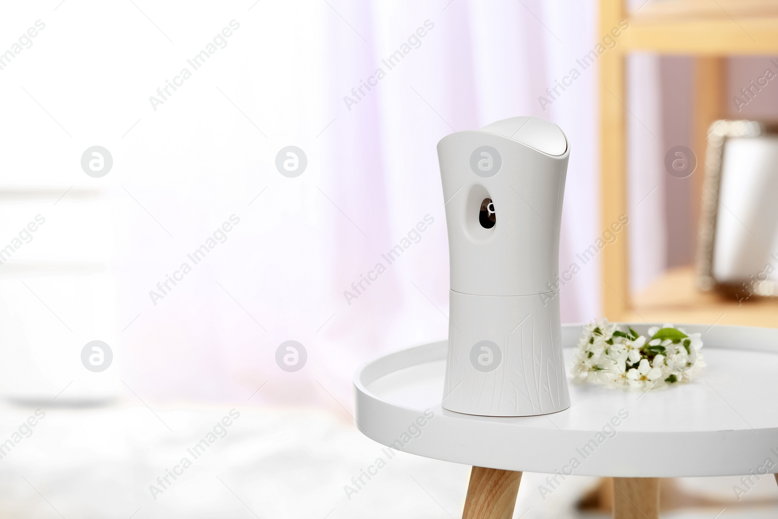 Photo of Automatic air freshener on table in room