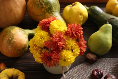 Photo of Beautiful chrysanthemum flowers in vase and pumpkins on wooden table, above view. Autumn still life