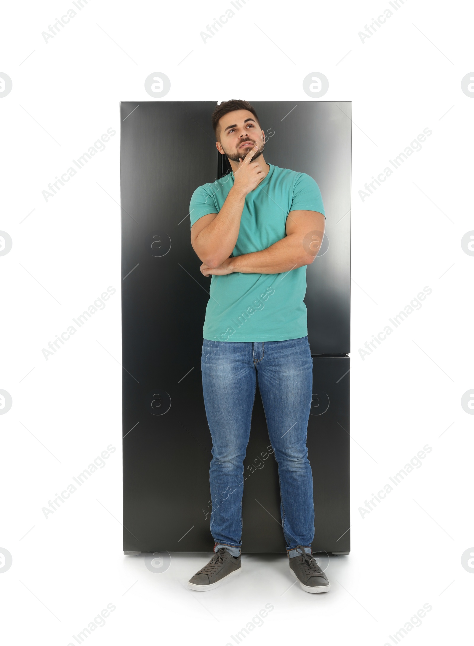 Photo of Young man near refrigerator on white background