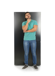 Photo of Young man near refrigerator on white background