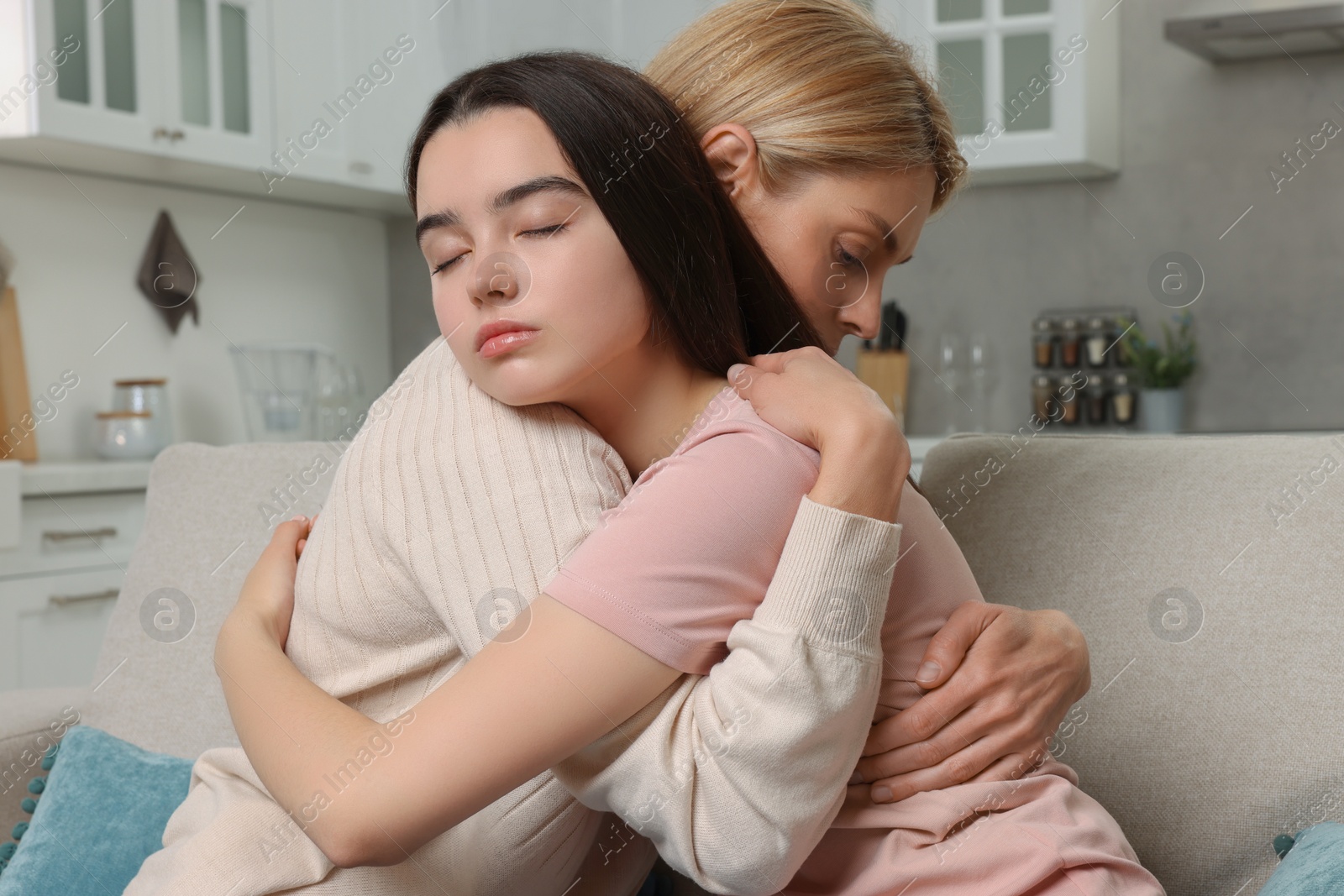 Photo of Mother consoling her upset daughter at home. Teenager problems