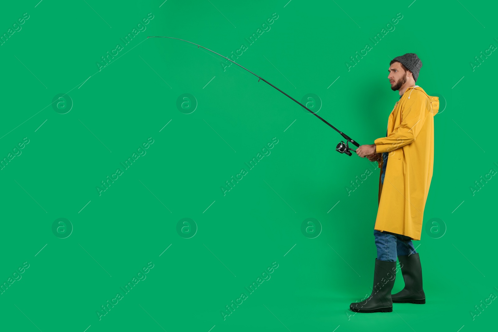 Photo of Fisherman with fishing rod on green background, space for text