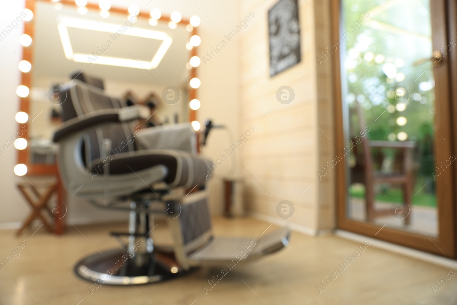 Photo of Blurred view of stylish barbershop interior with hairdresser workplace