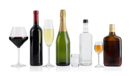 Bottles and glasses with different alcoholic drinks isolated on white